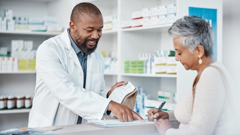 Une femme est conseillée par un pharmacien