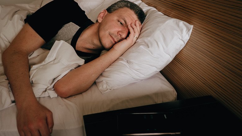 homme fatigué essayant de dormir