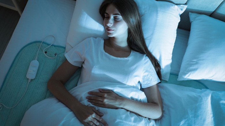 Femme dormant sur un coussin chauffant