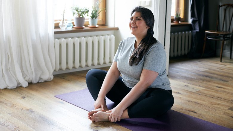 femme sur un tapis de yoga