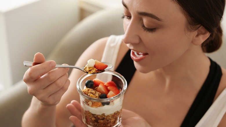 femme mangeant du yaourt et du granola