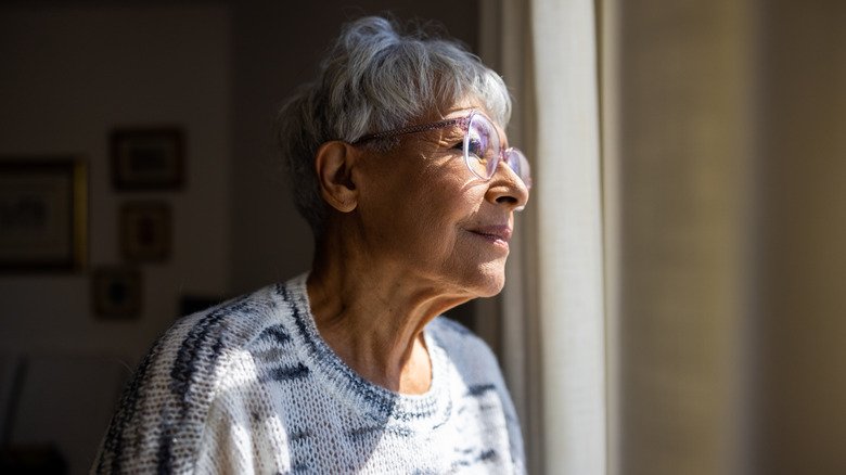 femme âgée regardant par la fenêtre