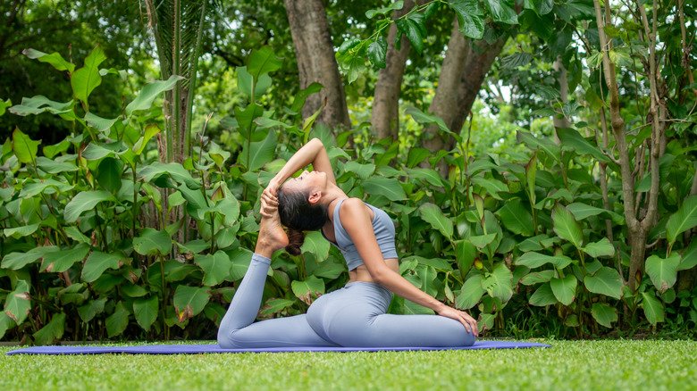 Femme pratiquant la posture de yoga à l'extérieur