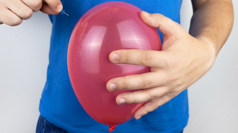 personne sur le point d'éclater un ballon