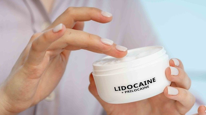 Une femme prend une crème anesthésiante à la lidocaïne