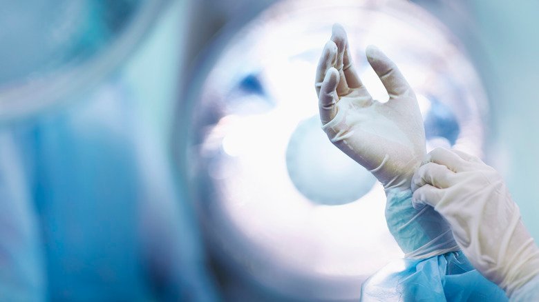 Les mains gantées du médecin au bloc opératoire