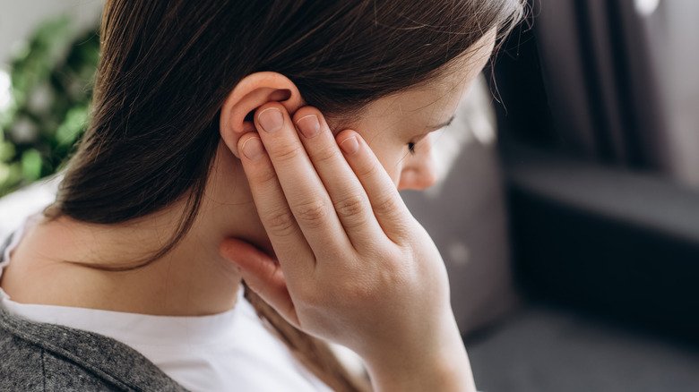 personne touchant l'oreille