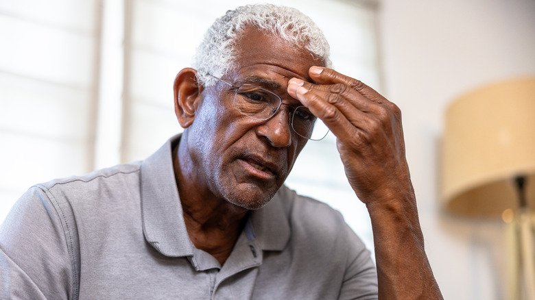 Homme fatigué touchant le front