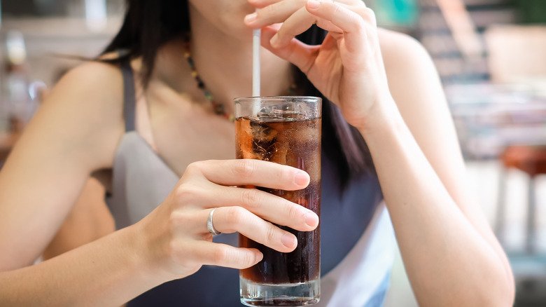 Femme buvant un verre de soda