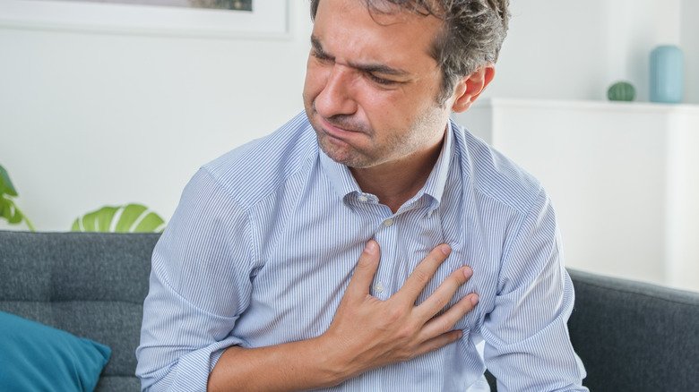 homme appuyant sa main sur sa poitrine