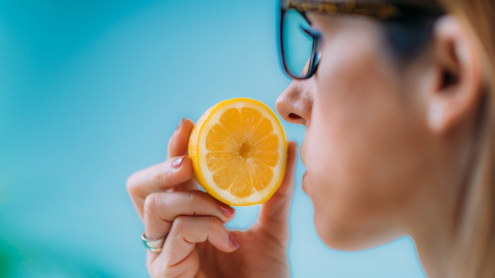 Une femme renifle une demi-orange