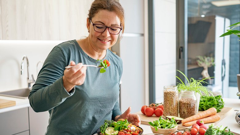 femme mangeant des légumes sains et des céréales complètes