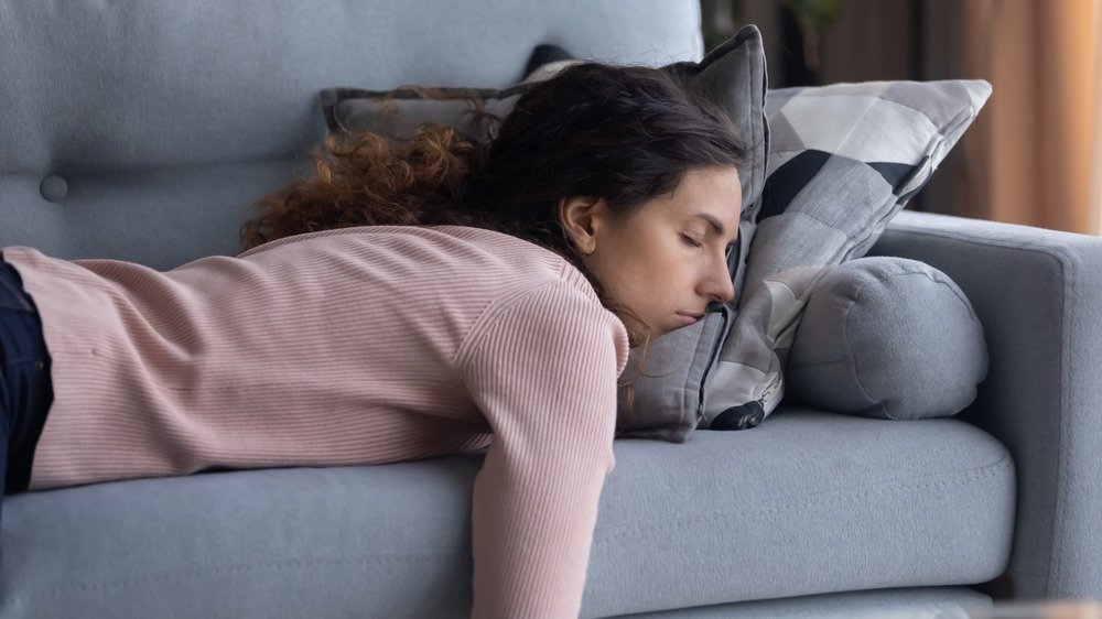 Jeune femme faisant la sieste sur un canapé