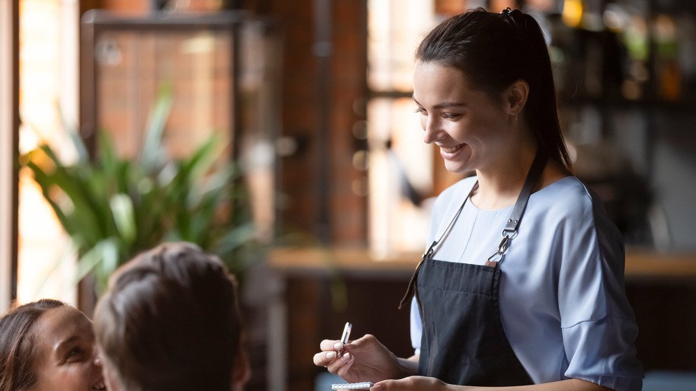 Serveuse prenant la commande à table