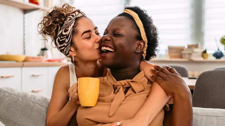 Couple souriant s'embrassant sur la joue