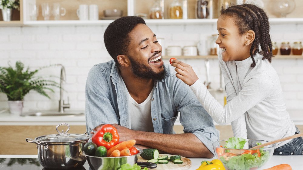 fille donnant des légumes à son père