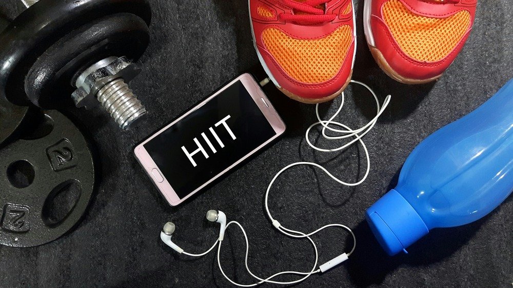 Poids, bouteille d'eau, baskets, téléphone portable avec les lettres HIIT dessus