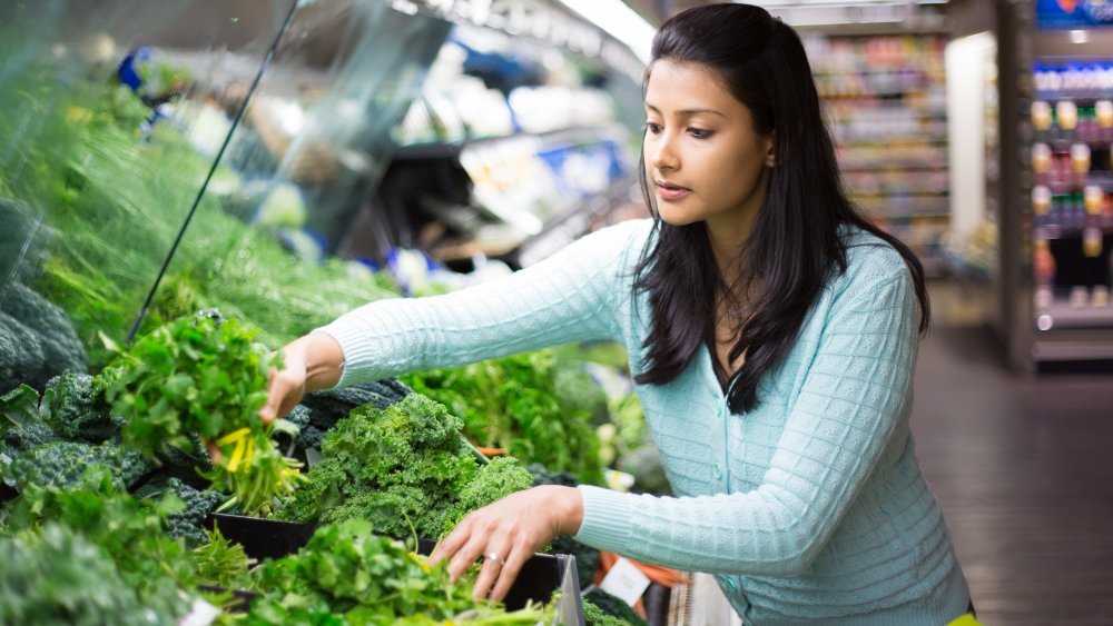 Femme choisissant des légumes verts