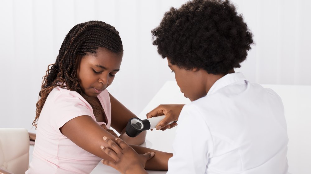 Une jeune fille afro-américaine consulte un dermatologue