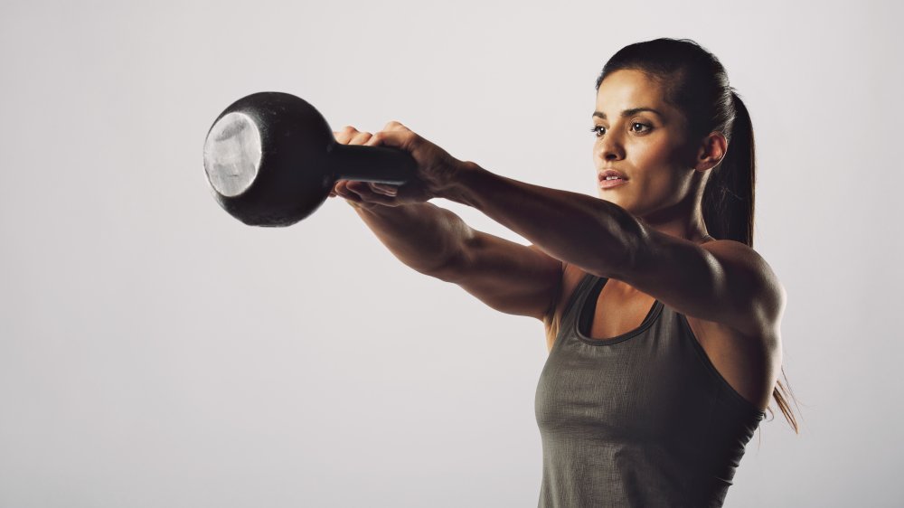 femme faisant des exercices avec kettlebell