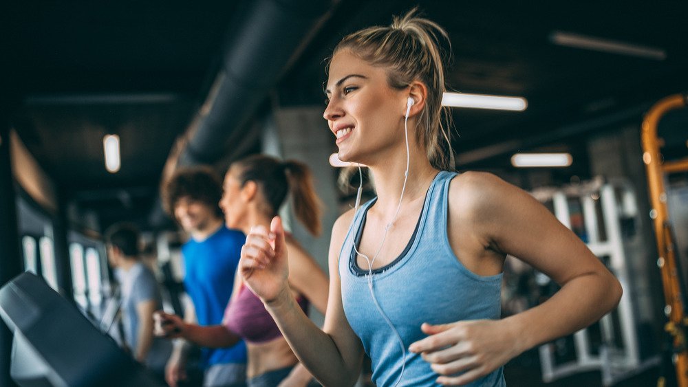 Des gens sur un tapis roulant dans une salle de sport