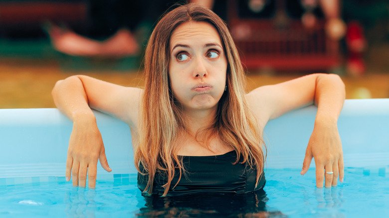 Jeune femme incertaine dans la piscine