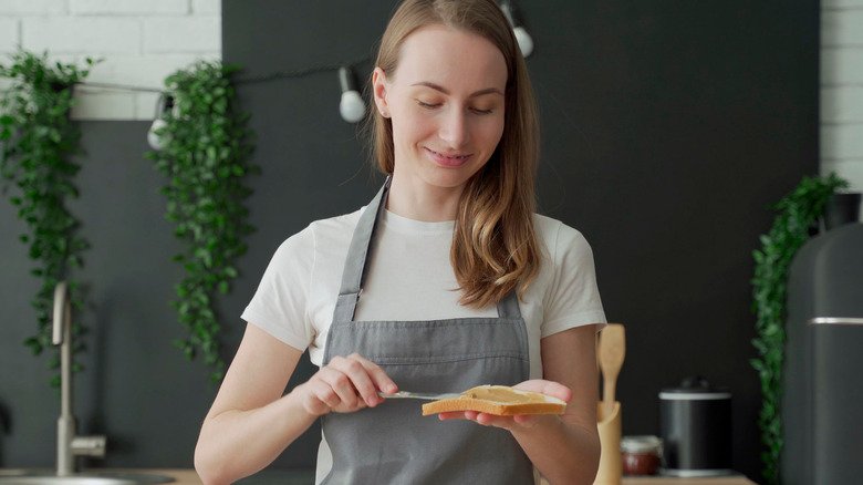 Femme préparant un sandwich au beurre de cacahuète