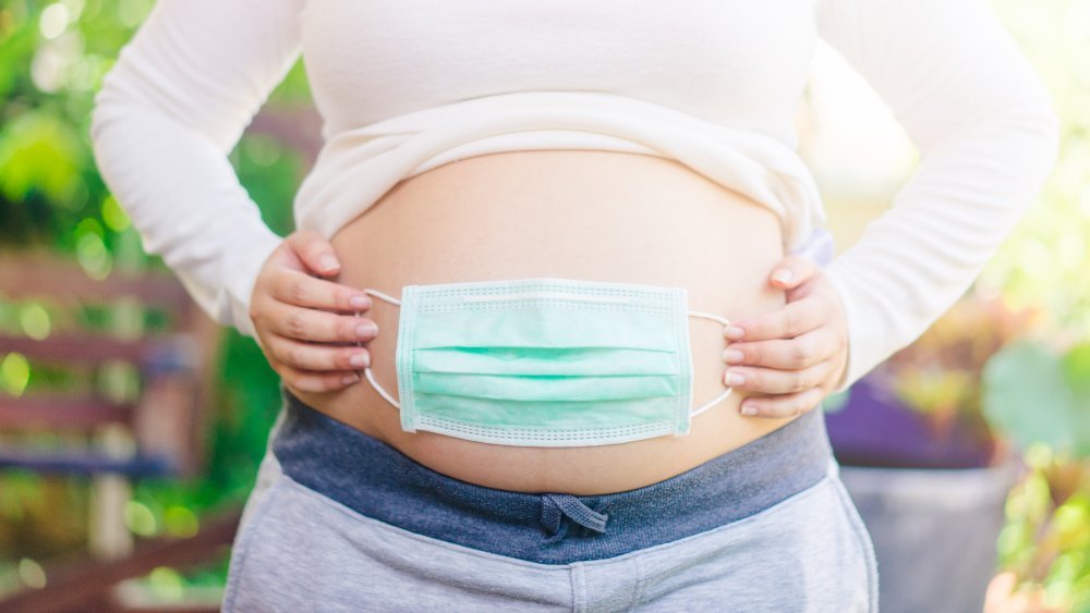 Masque facial sur le ventre de femme enceinte