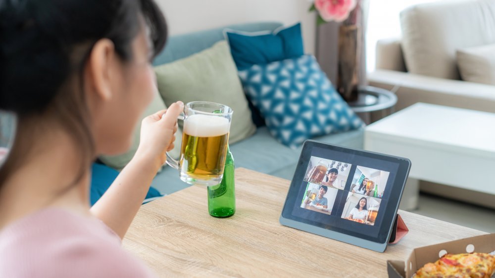 Une femme boit de la bière lors d'un appel vidéo