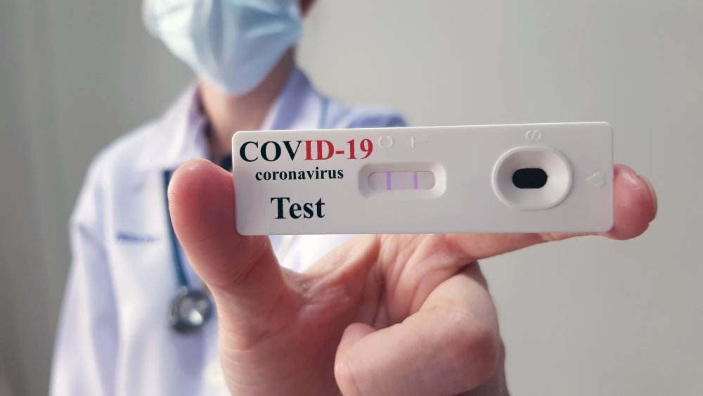 Un médecin montre un test positif à la COVID-19