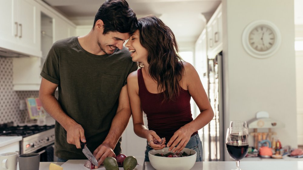 homme et femme préparant la nourriture dans la cuisine