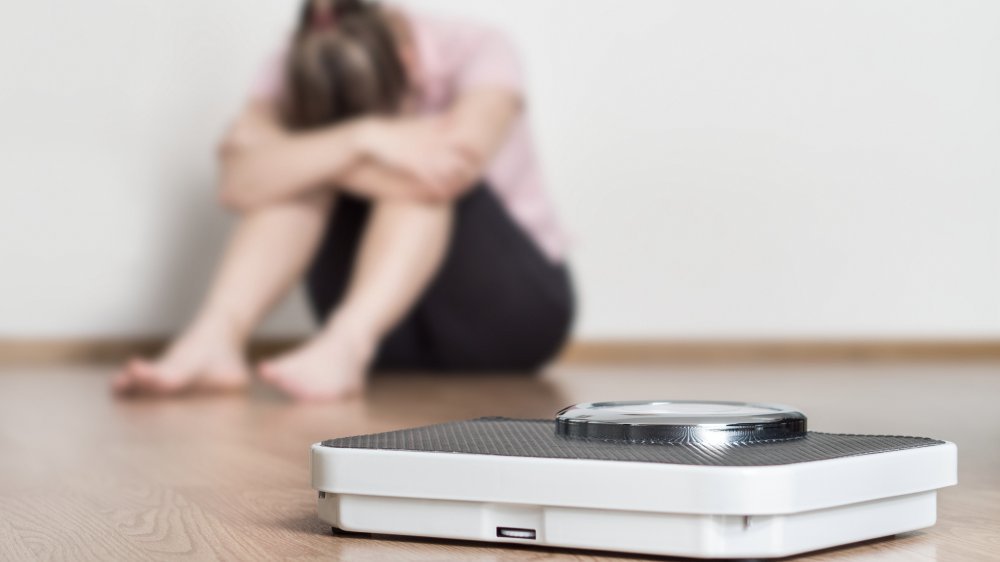 Échelle et femme déprimée, frustrée et triste assise sur le sol 