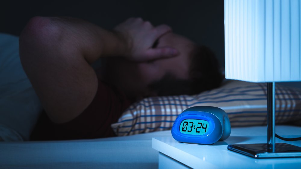 Réveil et homme malade au lit ne peuvent pas dormir