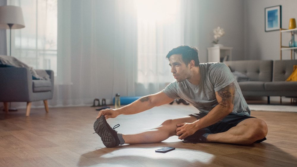 un homme s'étire dans le salon