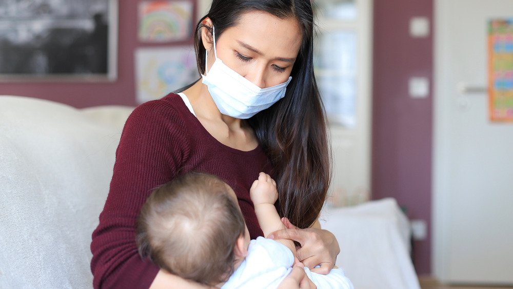 Femme qui allaite avec un masque