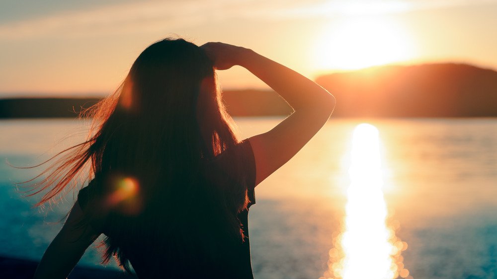 Une femme protège ses yeux du soleil