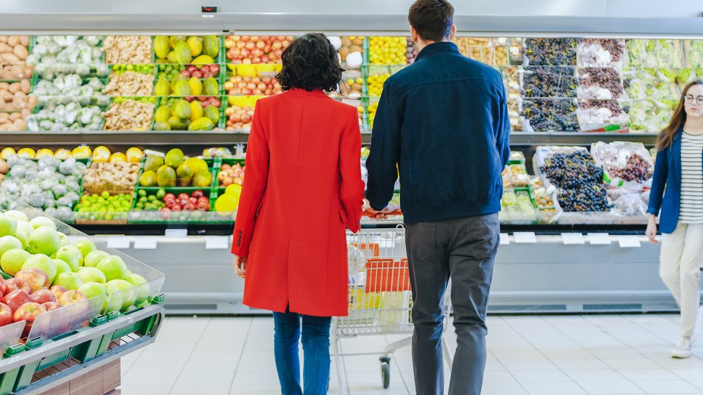 Couple faisant ses courses dans le rayon des fruits et légumes