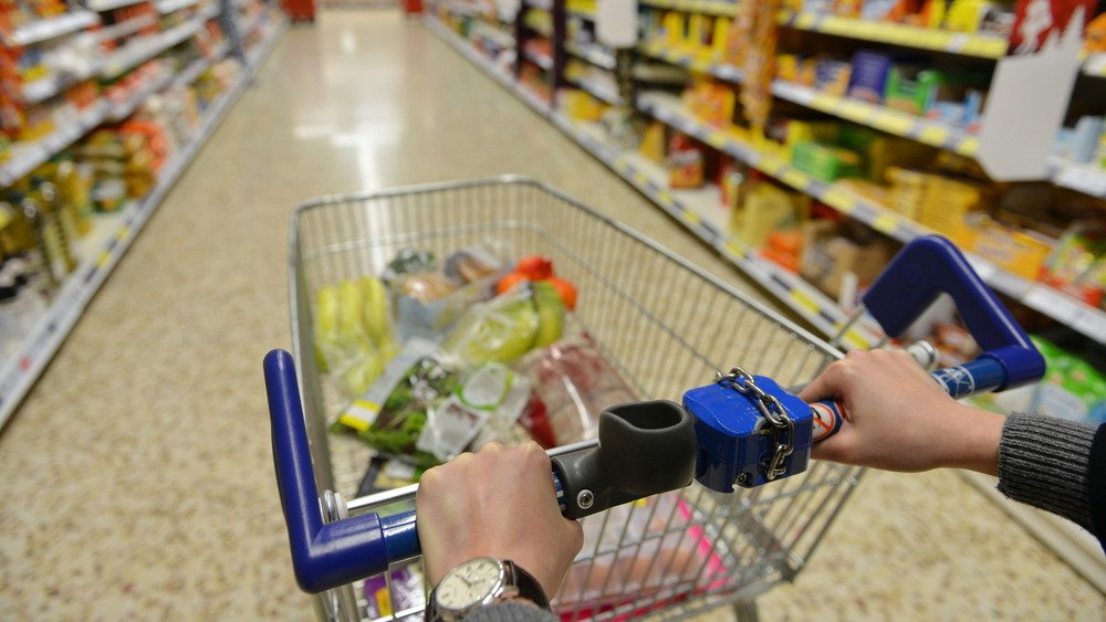 Femme poussant un chariot d'épicerie