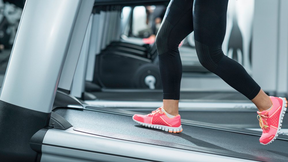 Femme utilisant un tapis roulant sur une pente