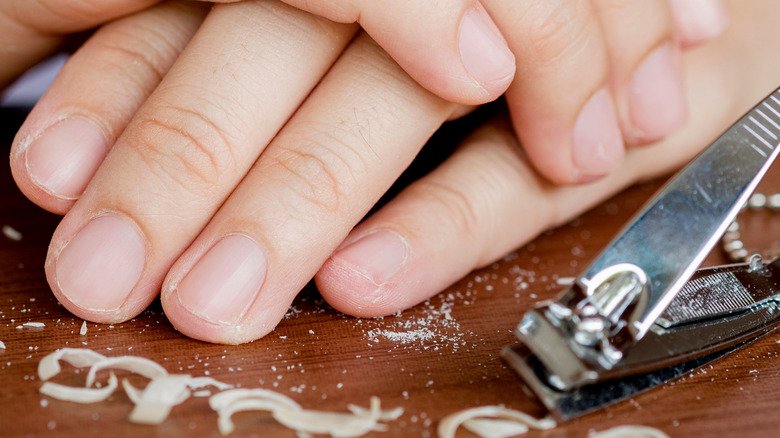 Les ongles d'une femme trop coupés avec un coupe-ongles 