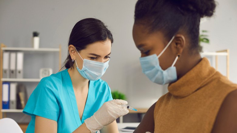 Un professionnel de la santé administre un vaccin à une femme