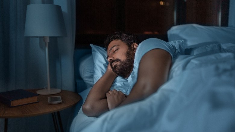 Un homme dort profondément dans son lit