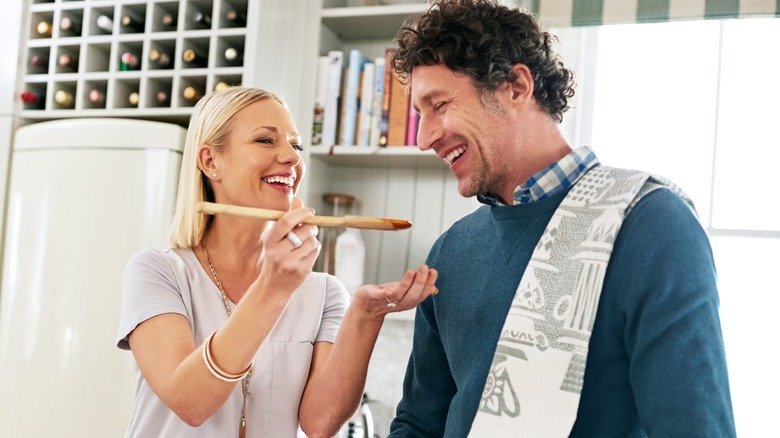 Couple souriant en train de cuisiner dans la cuisine