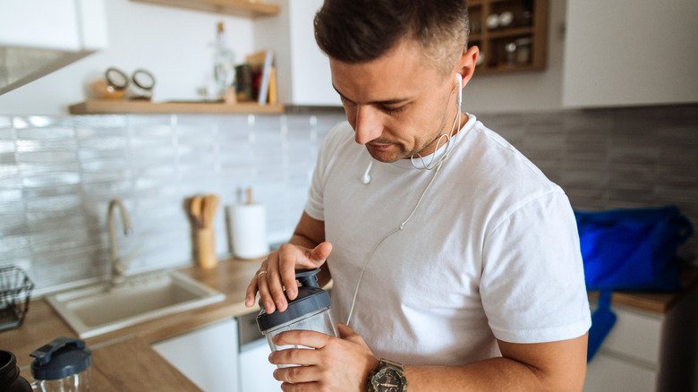 homme préparant un shake protéiné à base de lactosérum