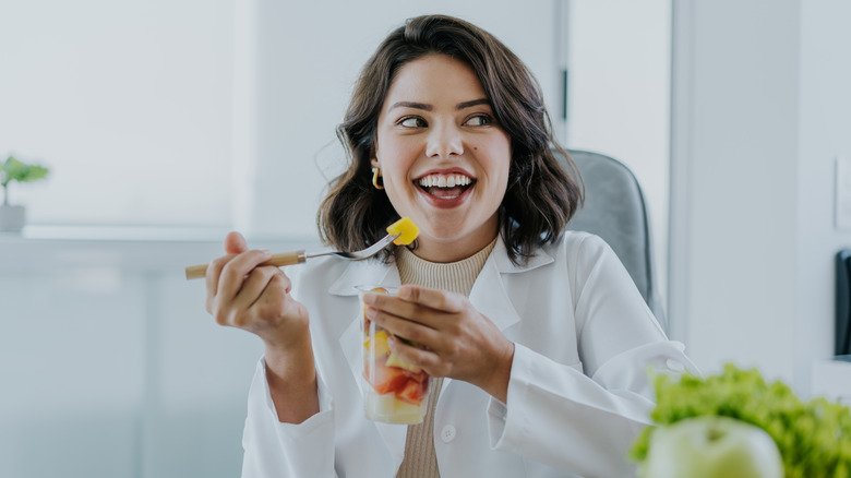 femme mangeant une salade de fruits