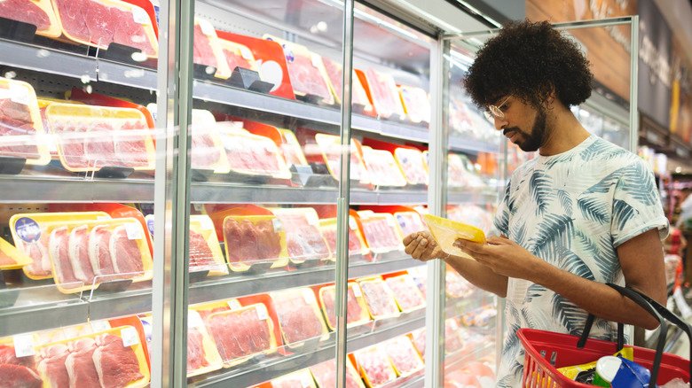 homme achetant de la viande dans une épicerie