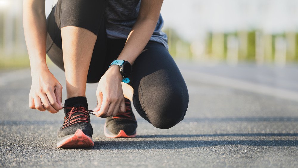 femme attachant une chaussure de course