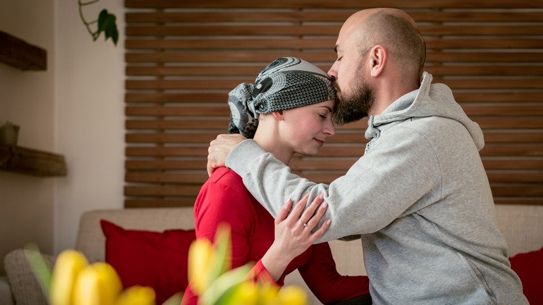 Un mari embrasse sa femme atteinte d'un cancer