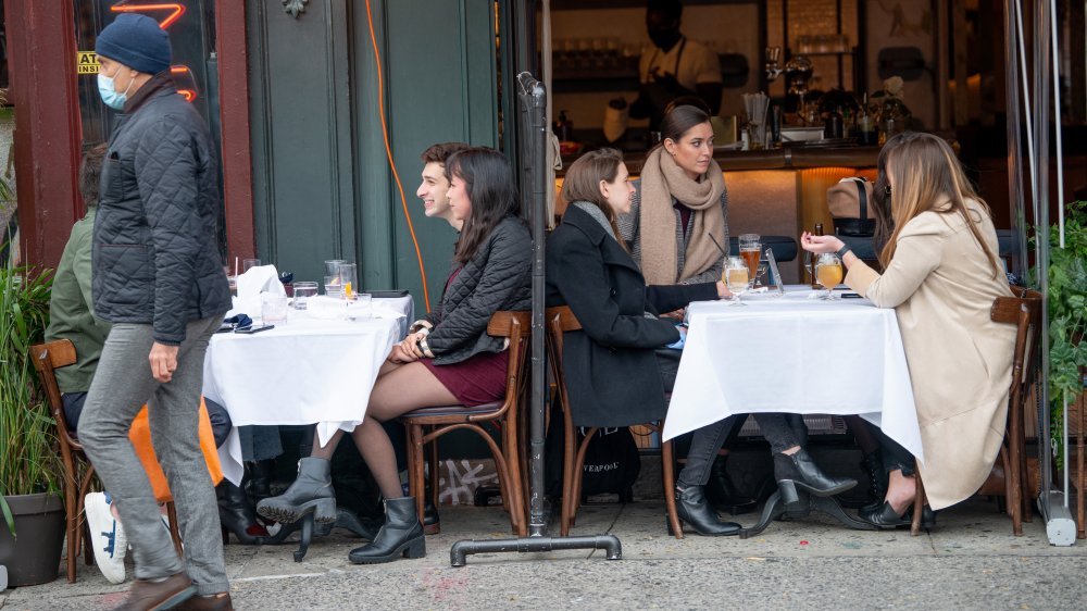 Les hommes et les femmes dînent en plein air