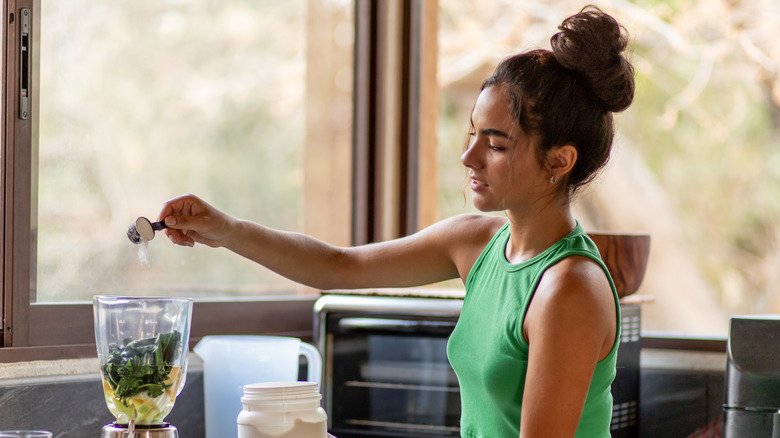 Jeune femme préparant un smoothie